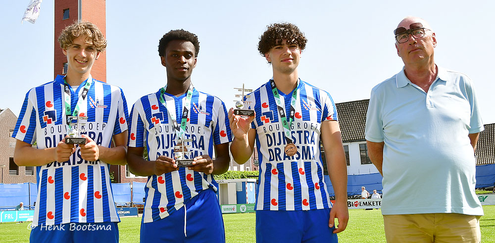 Three young players in blue-and-white striped jerseys hold trophies, flanked by a man in a light shirt on a sunny field.